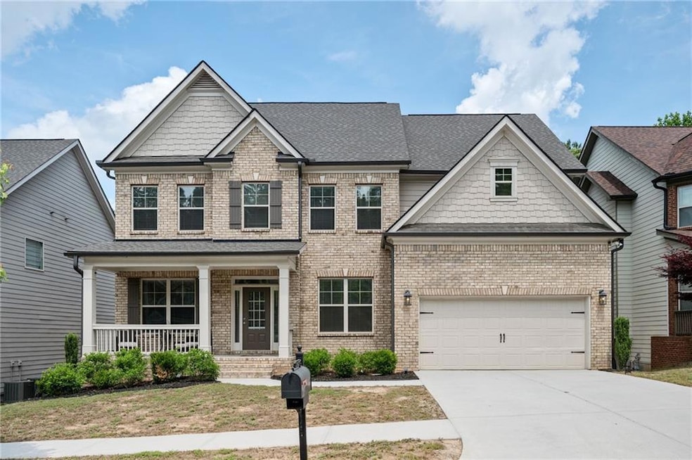 Craftsman-style home featuring covered porch, bric