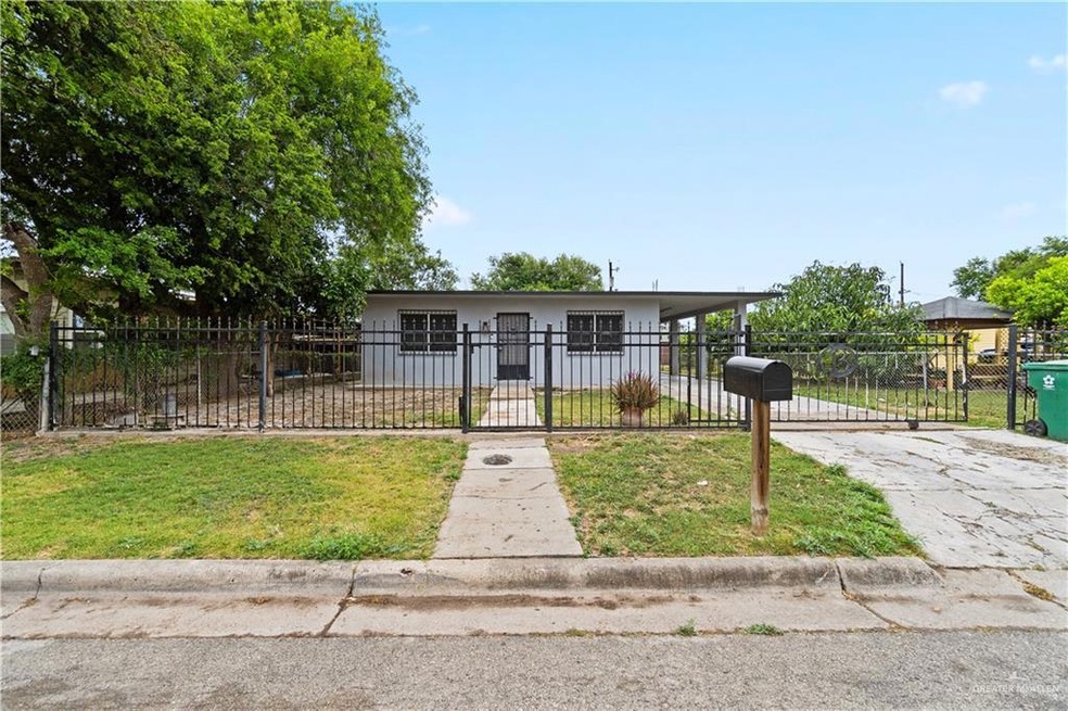View of front of property featuring a gate, an attached carport, driveway, and a fenced front yard