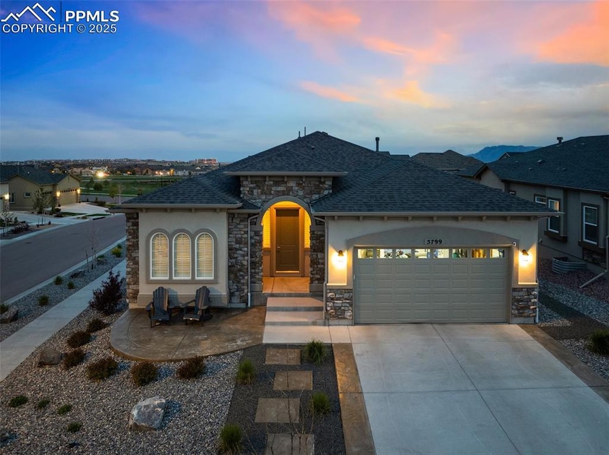 French country style house featuring stone siding, a garage, concrete driveway, stucco siding, and a shingled roof