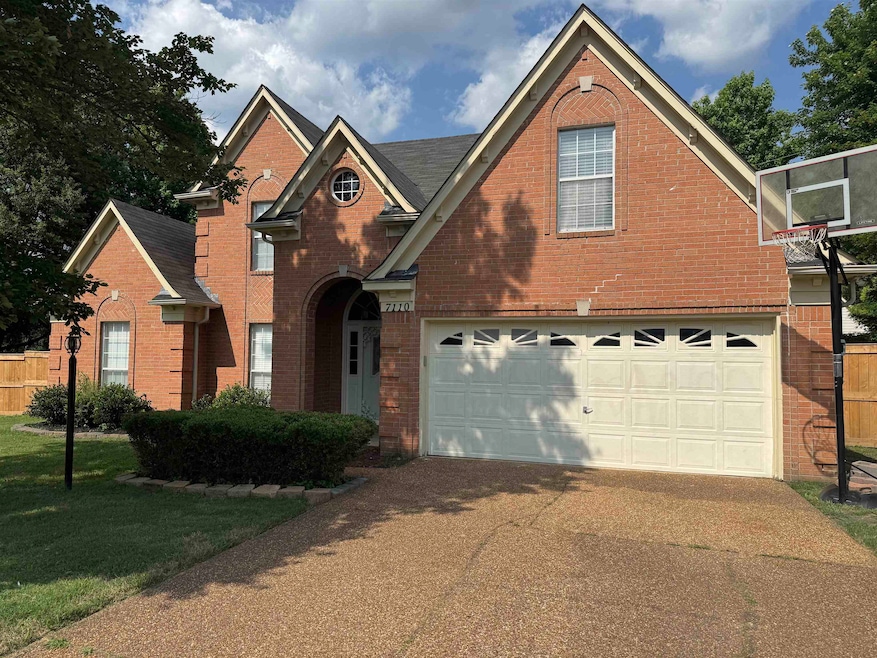 Traditional-style house with brick siding and concrete driveway