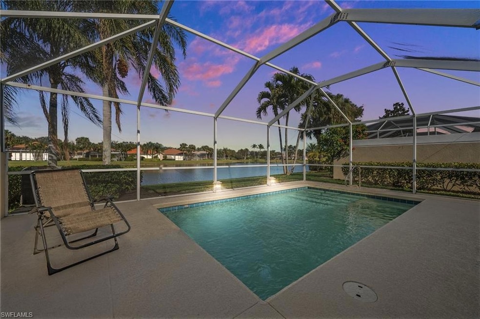 Pool at dusk featuring a lanai, a patio, a water v
