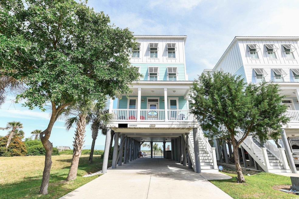Raised beach house featuring a carport, a porch, a