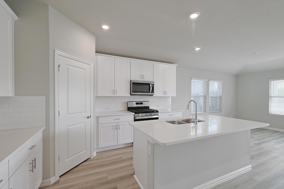 3305 Chasemoor Drive is a gorgeous home that boasts a stylish kitchen featuring quartz countertops, an island and luxury vinyl plank flooring.