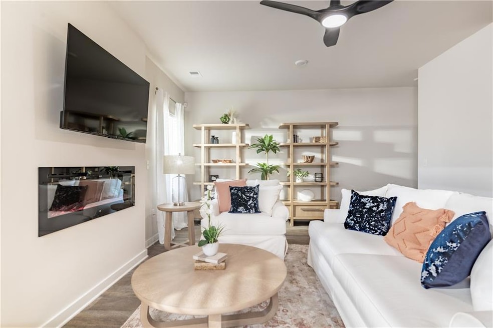 Living area with a ceiling fan, baseboards, a glas