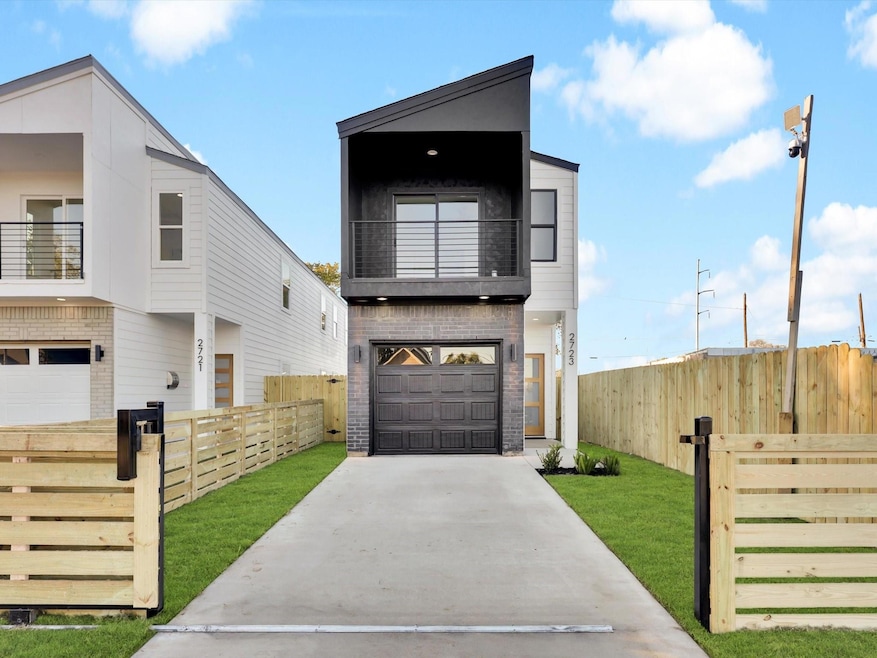 Modern home featuring a balcony, a front yard, and