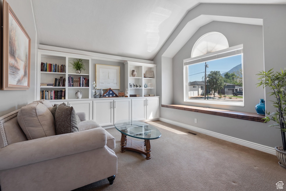Sitting room with lofted ceiling and carpet