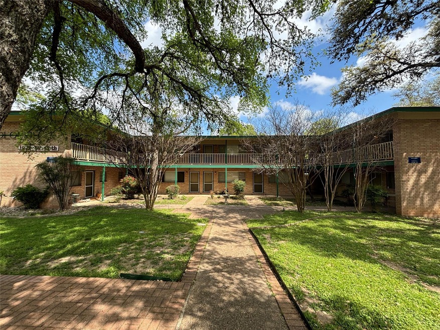 Back of house featuring brick siding and a yard