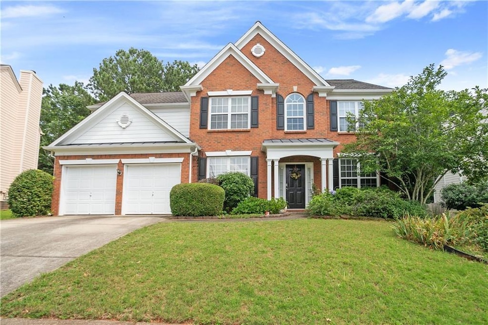 View of front of house featuring brick siding, concrete driveway, a front lawn, a standing seam roof, and a garage