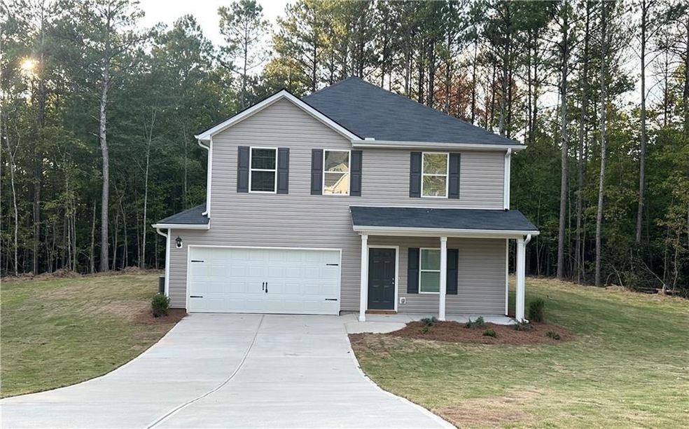 View of front of property featuring a front lawn, covered porch, and a garage