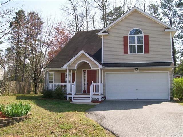 Front of house with nice landscaping and paved drive.