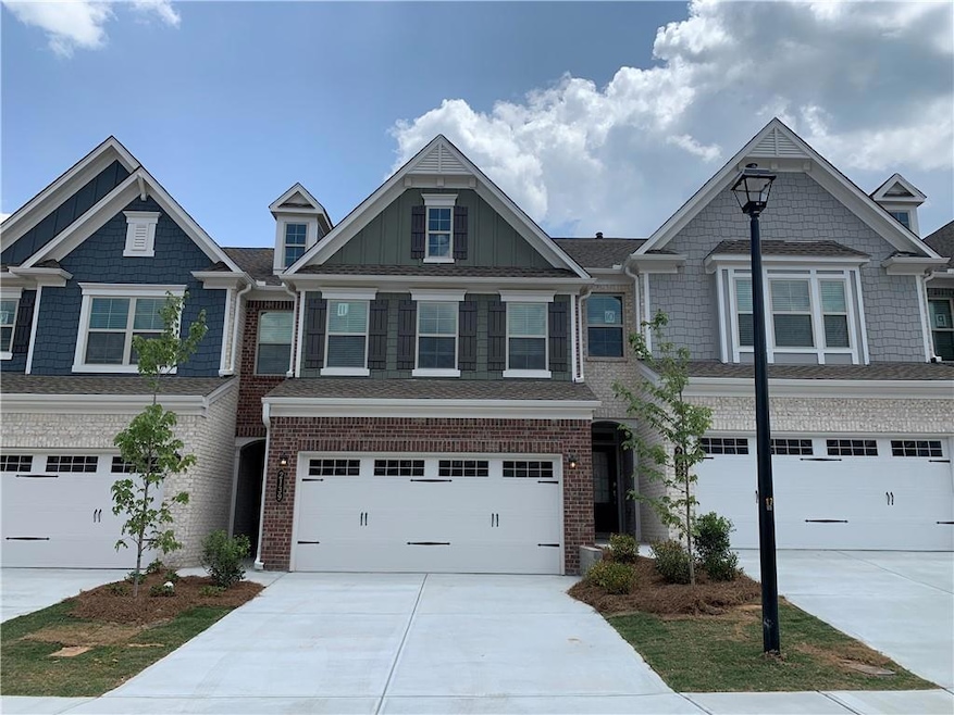 View of front of home featuring driveway, a garage, and brick siding