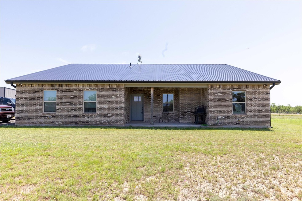 Back of property with a lawn