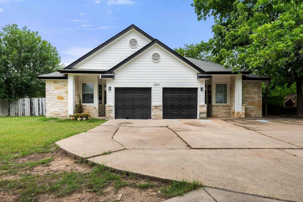 View of front facade with a garage, fence, a fron