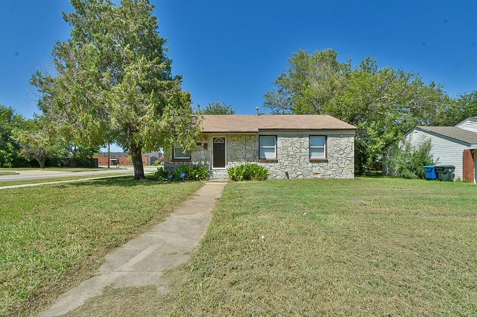 Single story home featuring stone siding and a front yard