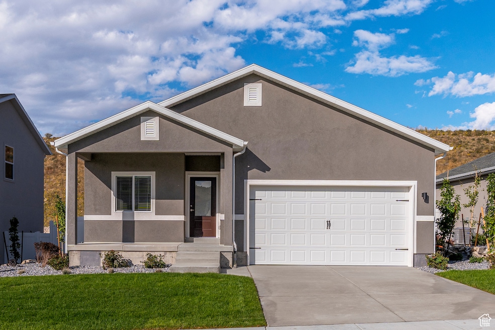 Ranch-style house with driveway, stucco siding, a front lawn, and a garage