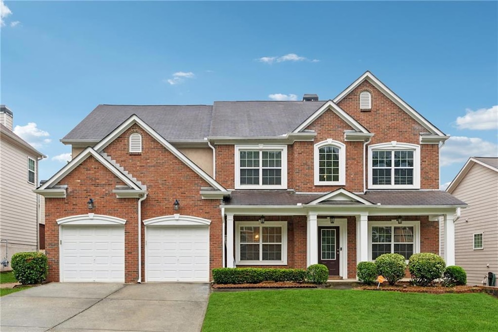 View of front of home with concrete driveway, a front yard, brick siding, a shingled roof, and a chimney