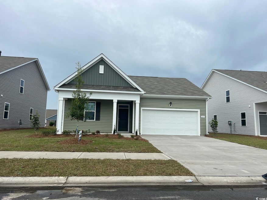 View of front of home with a front yard and a gara