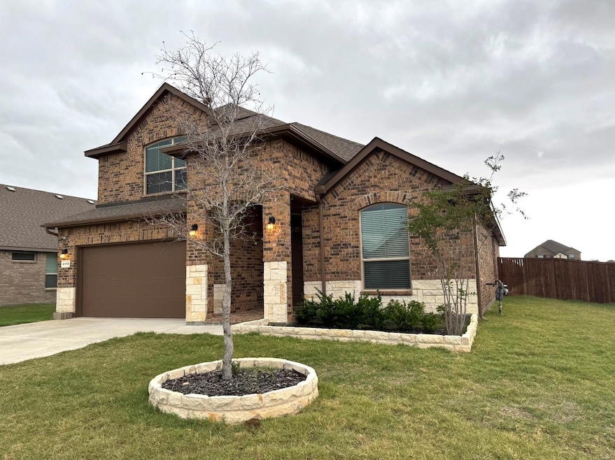 View of front of property featuring a front yard and a garage