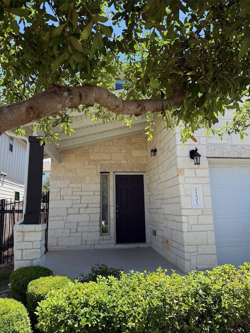 Doorway to property featuring stone siding and fe