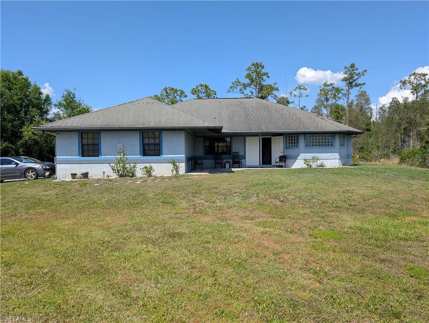 Back of house with a lawn, stucco siding, and a patio area