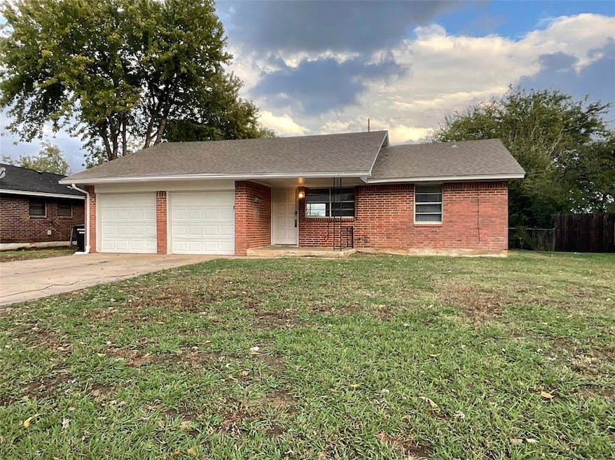 Single story home with a garage and a front yard
