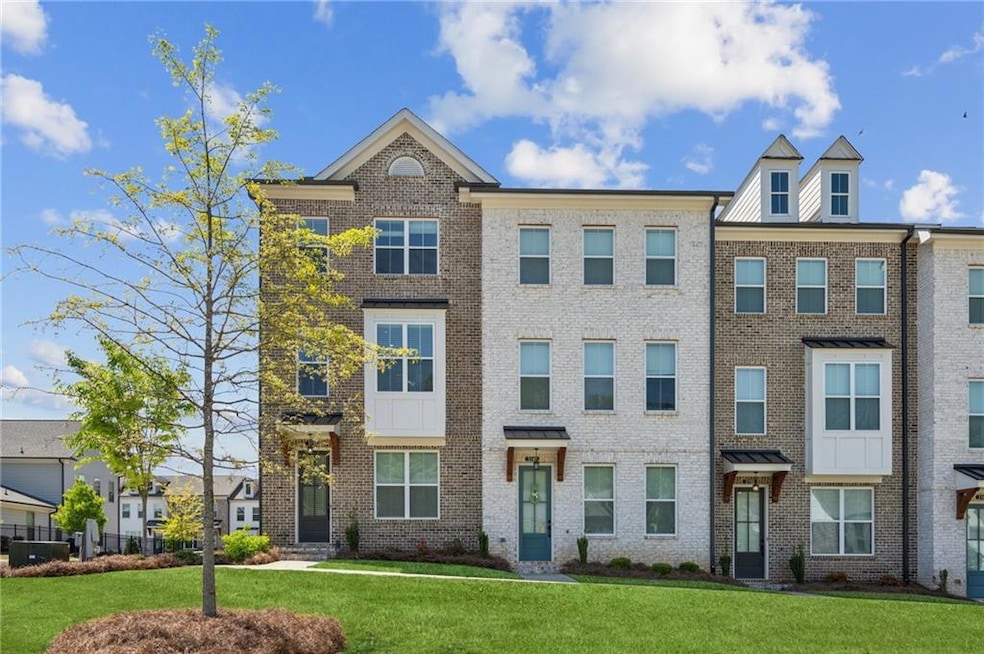 View of property featuring a front lawn and brick 