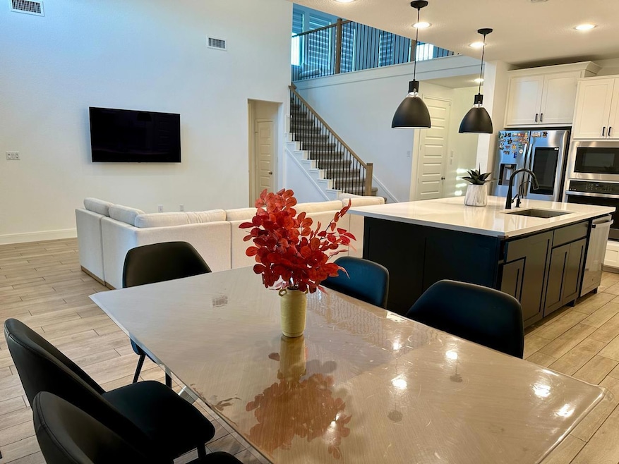Dining space featuring light wood-style flooring, stairway, recessed lighting, and a high ceiling