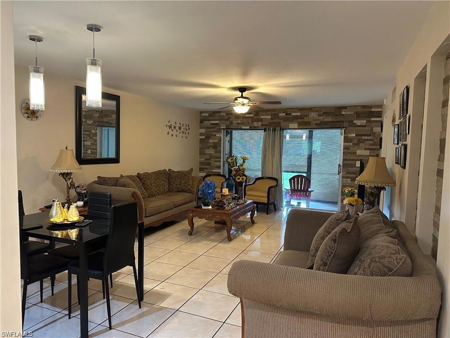 Living room with ceiling fan and light tile patter