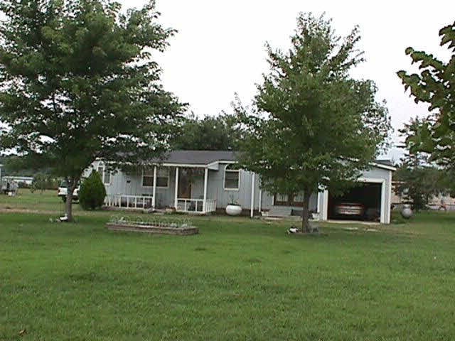 Front view showing depth of lot and shade trees.