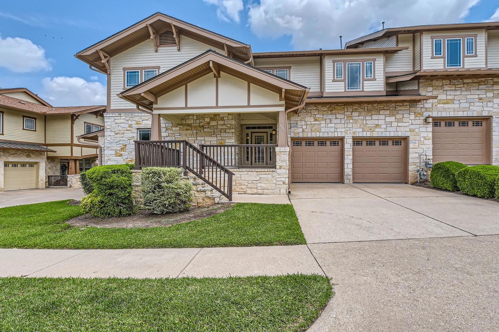 View of property featuring a porch, a garage, dri