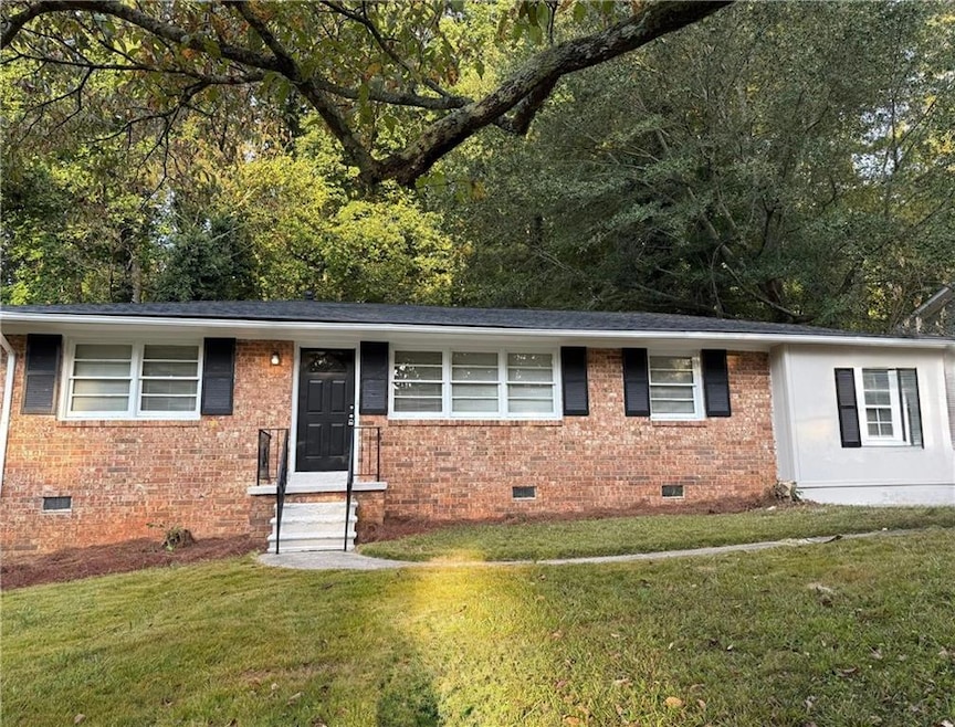 Ranch-style home featuring crawl space, brick siding, and a front yard