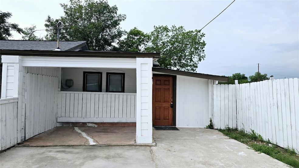View of outdoor structure with a porch and fence