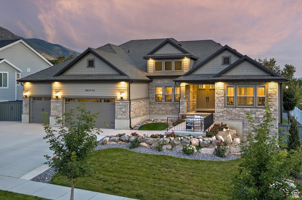 Craftsman house featuring driveway, stone siding, roof with shingles, and a garage