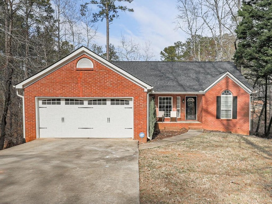 Single story home featuring brick siding, covered 