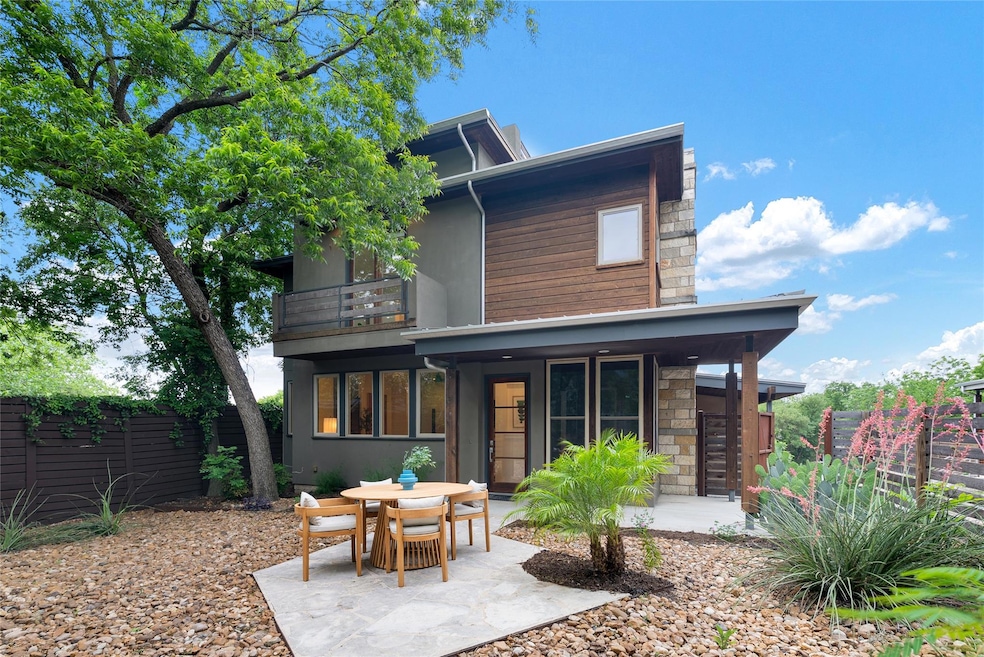 Rear view of property featuring stone siding, a p