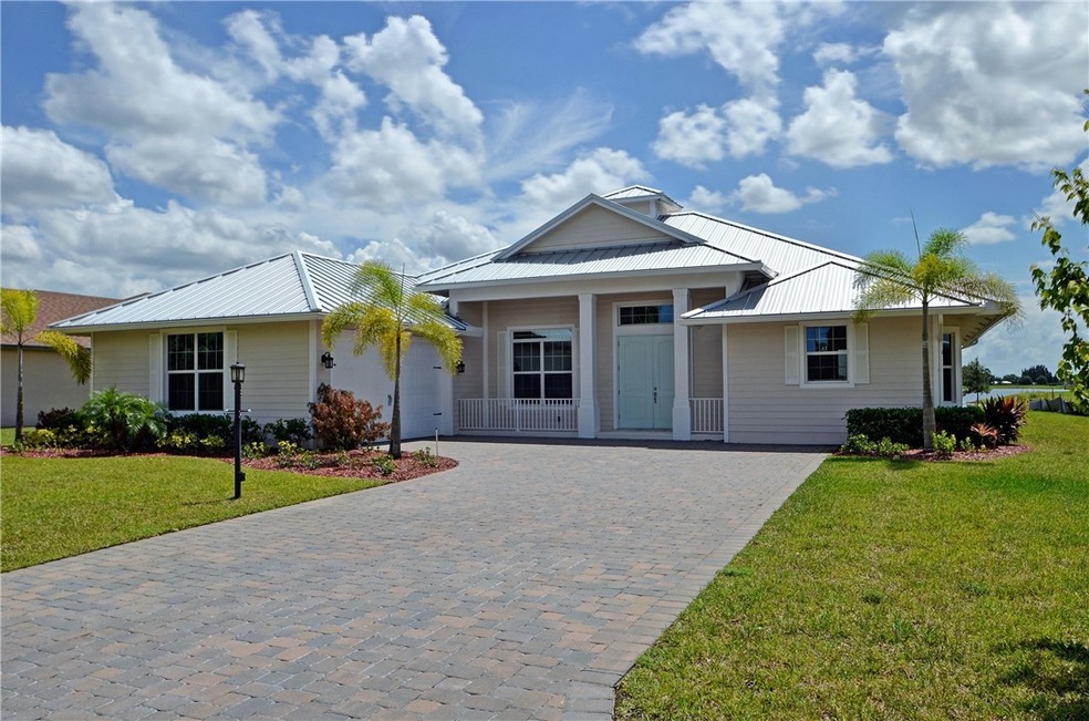 Elegant model home features brick paver driveway a