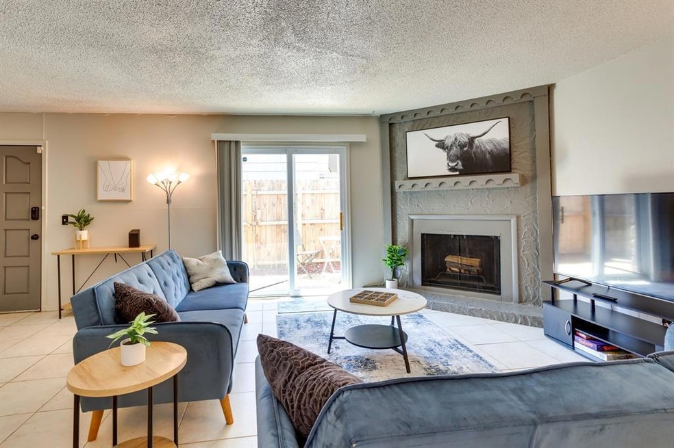 Tiled living room with a large fireplace and a tex
