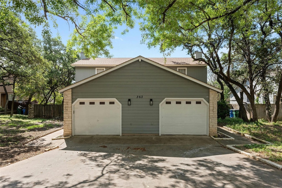 View of front of property with fence, a garage, d