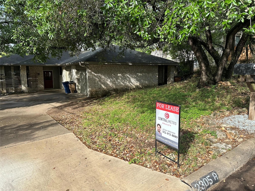 View of side of home featuring concrete driveway 