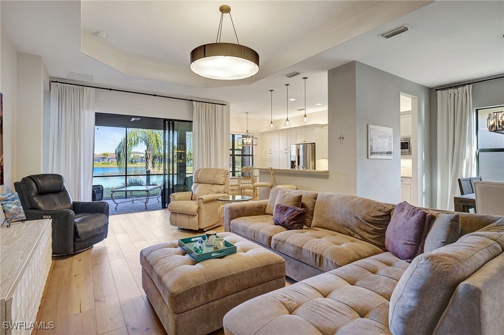 Living room featuring a water view, a raised ceili