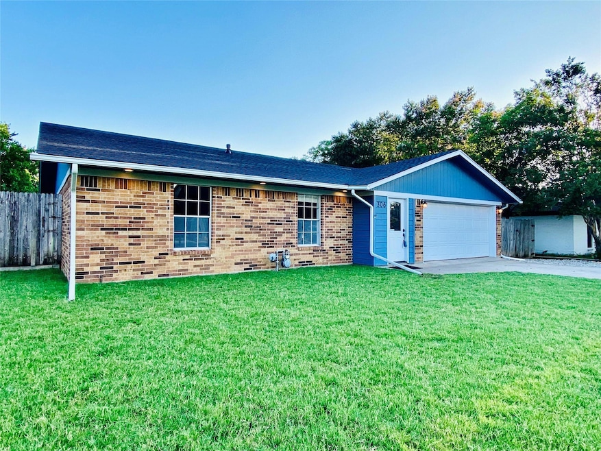 Ranch-style house featuring a front yard and a gar