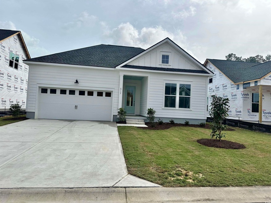 View of front of house with a garage and a front y