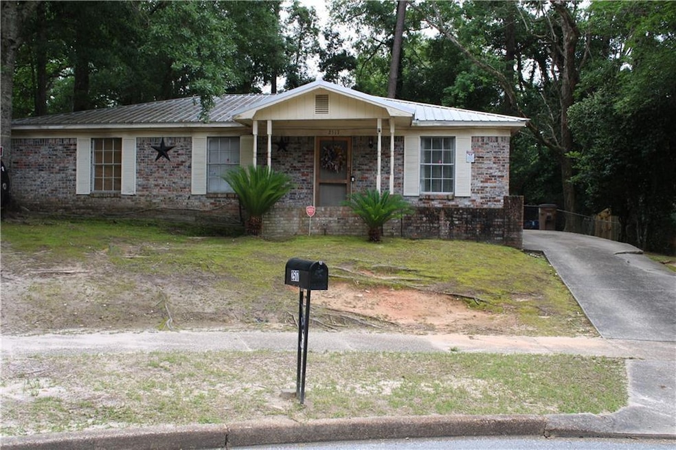Ranch-style home with metal roof, concrete drivewa