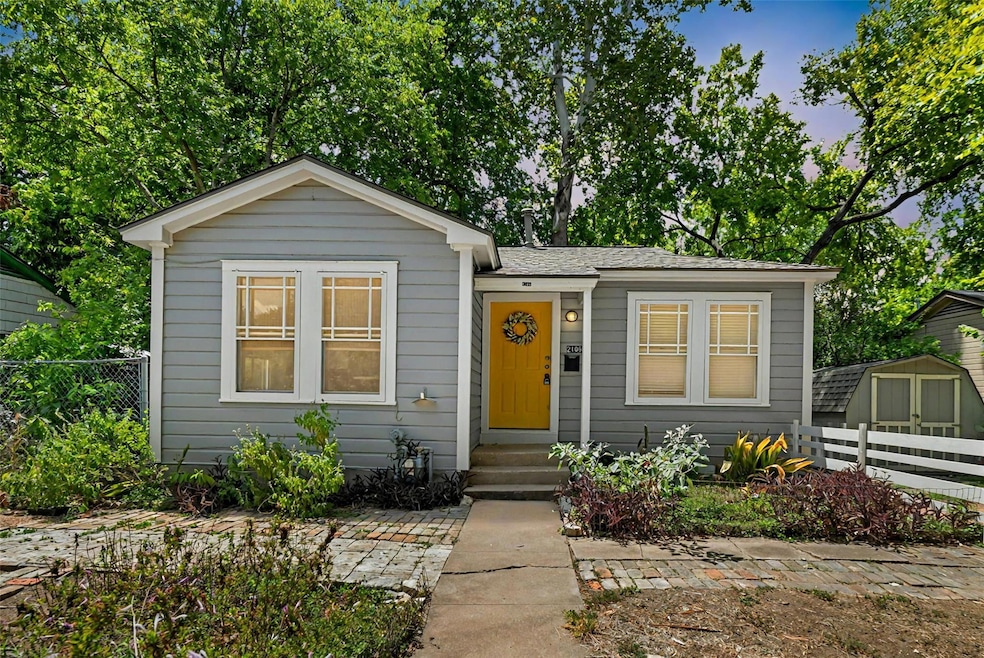 Bungalow-style house with a storage shed and a shingled roof