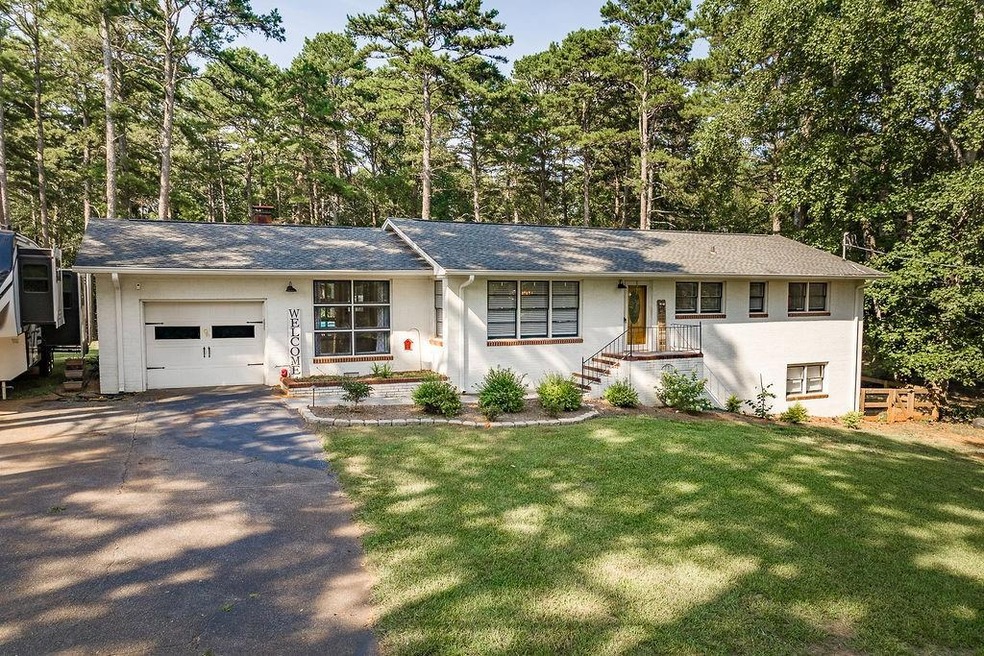 Ranch-style house featuring a garage and a front y