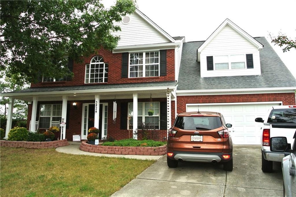 View of front of property featuring a garage, a front lawn, and a porch