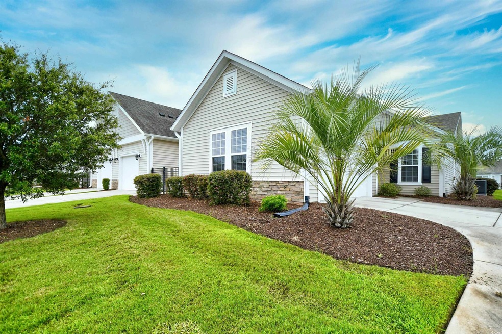 View of side of home with a garage and a lawn