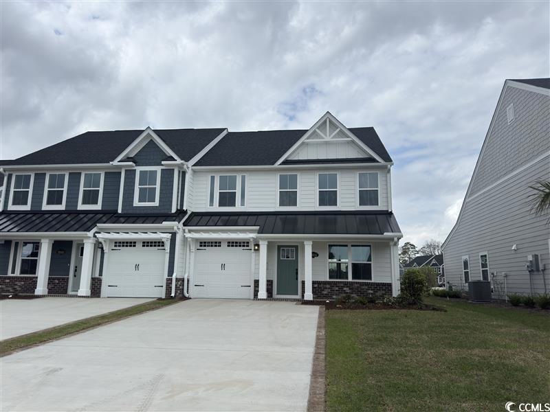 View of front facade featuring driveway, a standin