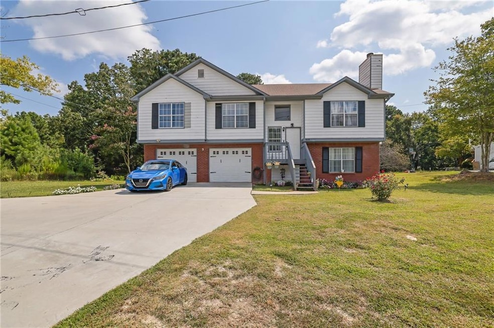 Raised ranch featuring brick siding, driveway, a chimney, a front lawn, and a garage