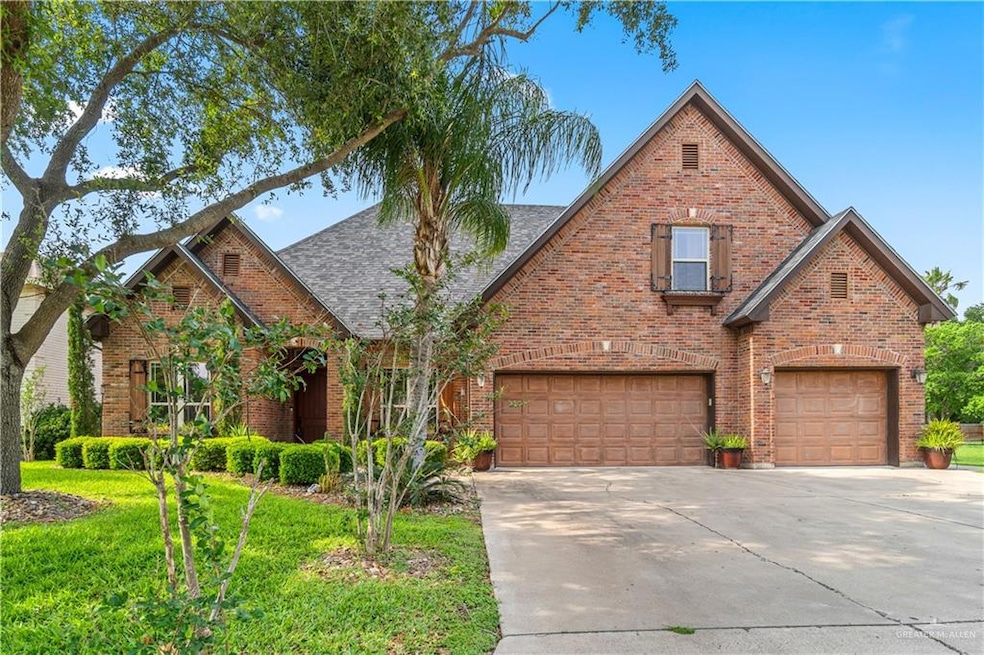 Traditional-style house with concrete driveway, a shingled roof, a front yard, brick siding, and a garage